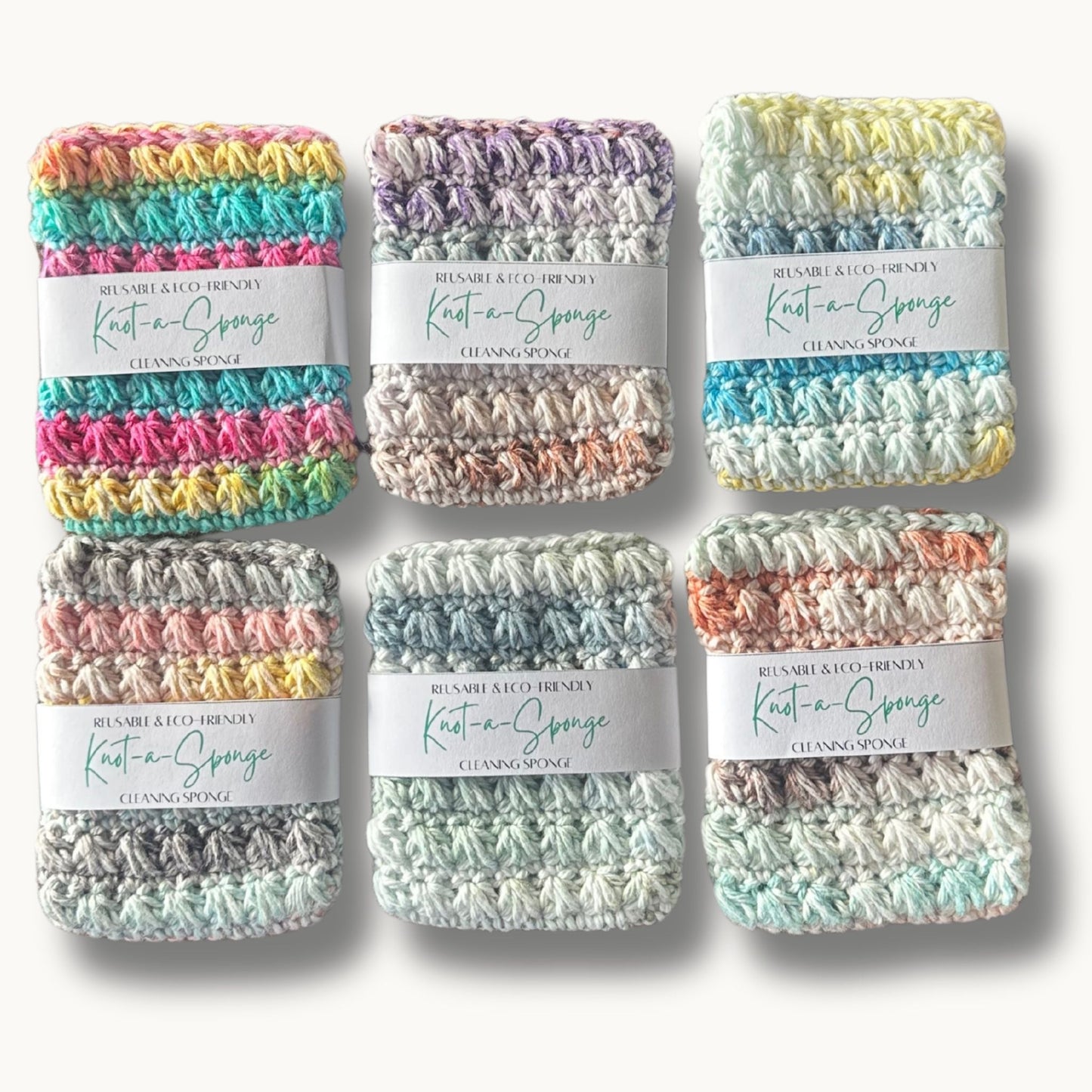 six kitchen sponges made of cotton yarn in variety of colors on a solid background with a label that says reusable & eco-friendly knot-a-sponge cleaning sponge