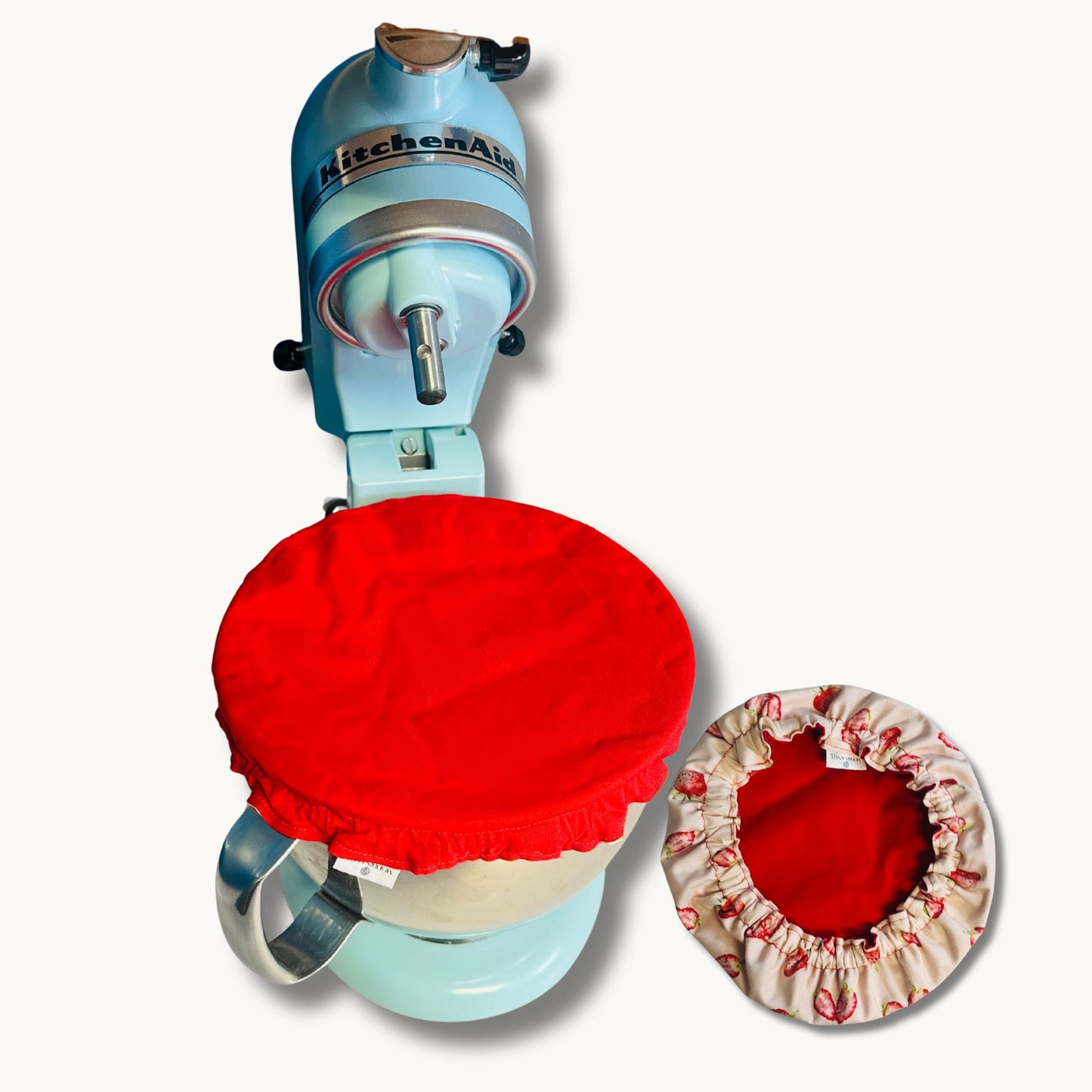 KitchenAid mixer with red and strawberry bowl cover on a white background