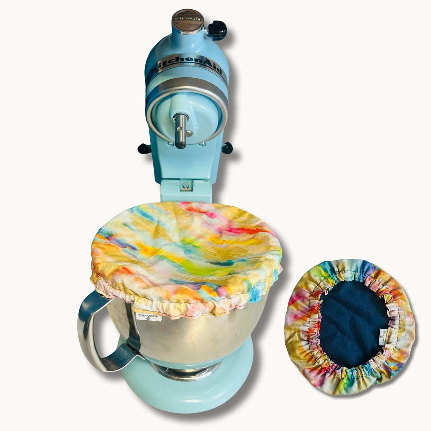 Blue stand mixer with colorful cover on a white background