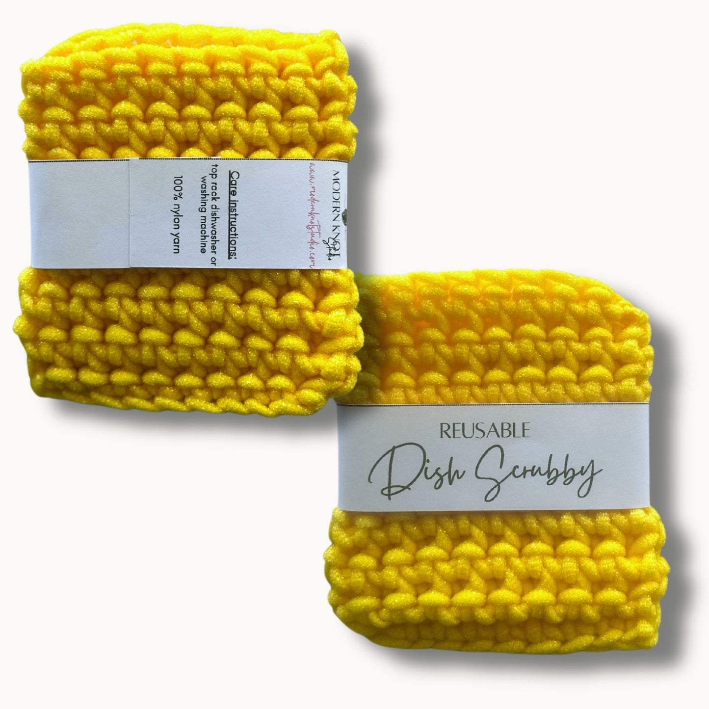 Two yellow crochet dish scrubbies with labels, one labeled 'REUSABLE DISH SCRUBBY' and the other with a care instruction label.