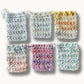 A collection of colorful cotton soap pouches with a crochet design and a drawstring closure.